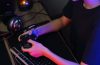 Female cyber hacker gamer playing or streaming video games on computer with joystick in neon light