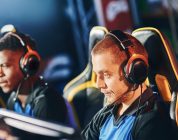 Team of four professional cybersport gamers wearing headphones participating in eSport tournament